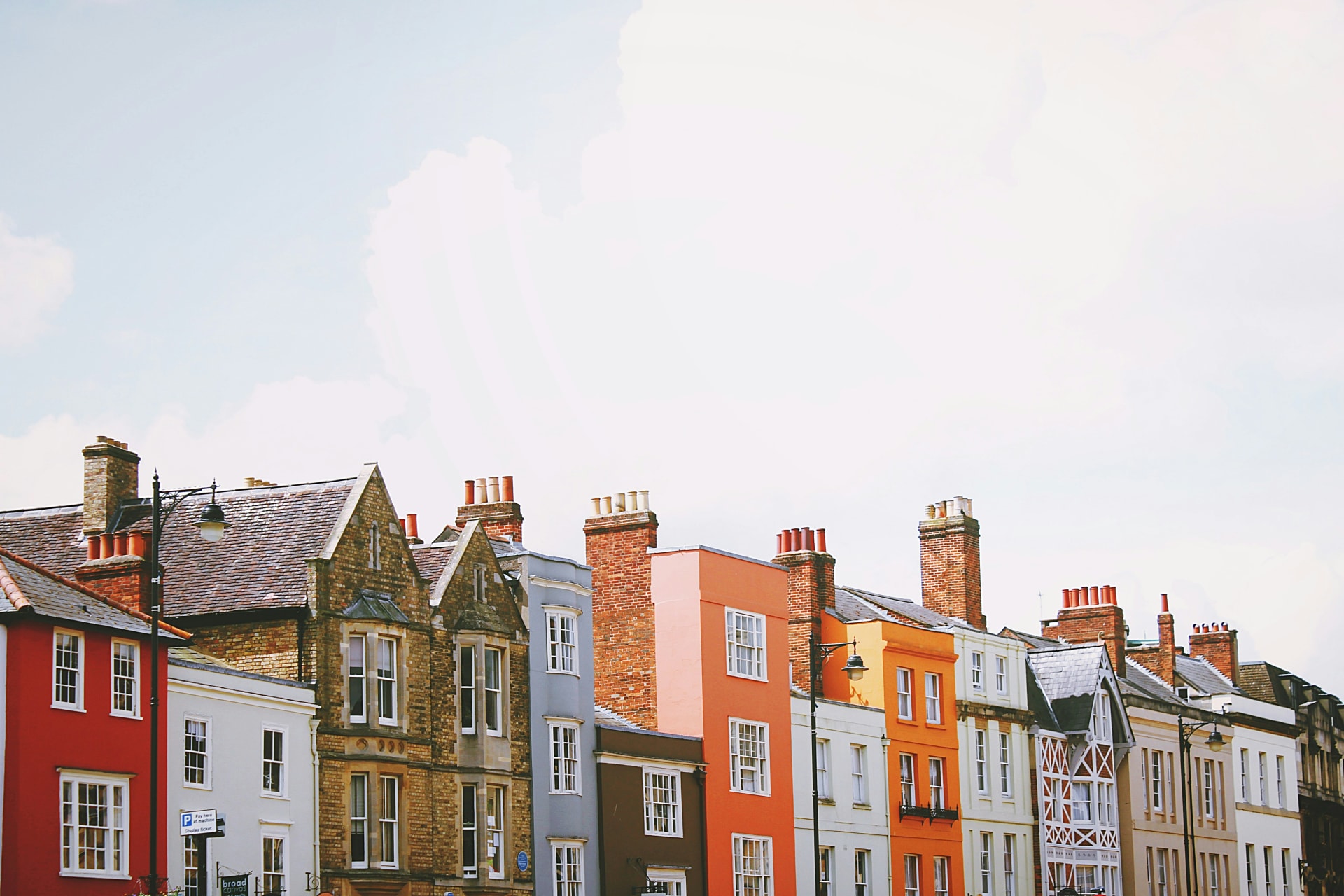 Assorted-color concrete houses under white clouds during daytime